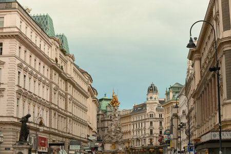 Wide view of Vienna's Graben street featuring the Plague Column, monumental statue, richly decorated historic buildings, and a clear sky.の写真素材