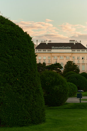 Beautifully trimmed shrubs in a Viennese garden, with a classical building visible in the distance, highlighting neat landscaping and lush greenery.の写真素材