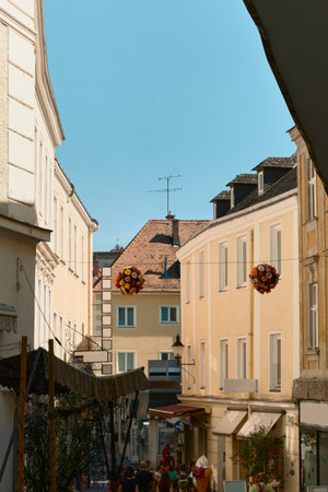 Photo of a sunny street in Wachau, Austria. Yellow building facade, neighboring houses, and colorful...