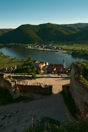 Scenic landscape with historic town of red rooftops, Danube River, vineyards, small village across the river and green forested hills on a bright clear summer day. UNESCO World Herの写真素材