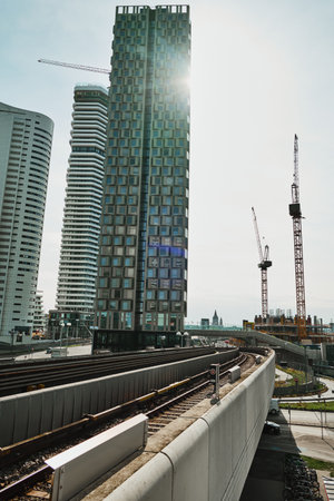 High-angle urban view showing skyscrapers with unusual windows, railway tracks in the foreground,...