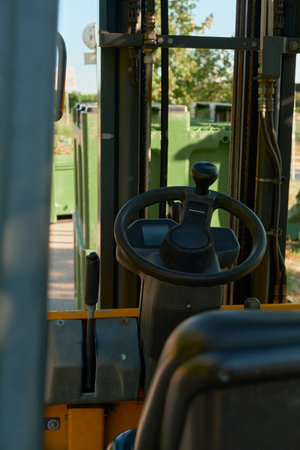Vertical steering photo showing the loader's wheel and gear lever. Sunlit, detailed view of...