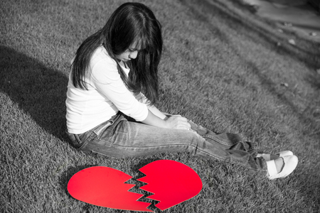 Broken red heart with sad young lady crying on Valentines day, fail love concept with black and white tone, selective focusの写真素材