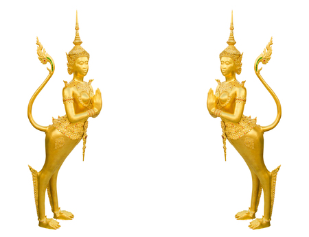 Beautiful gold Kinnara statues, guardian of Thai temple at Buddhist sanctuary isolated white background (clipping path included)の写真素材