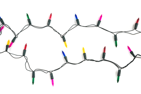 Christmas light bulbs on string in multi colours; blue, yellow, red, pink and green isolated on white background, Xmas holiday decoration concept (flat lay)の写真素材