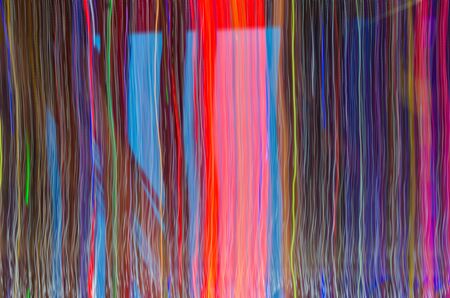 Blurred abstract colourful vertical lines in blue, red, pink, green and black colour light at night...