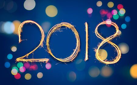 2018 Happy New Year of sparkle Light painted over twilight blue background with colourful Christmas...