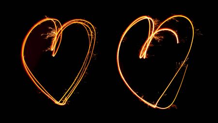 Sparkler light painted in shape as two hearts at night timeの写真素材