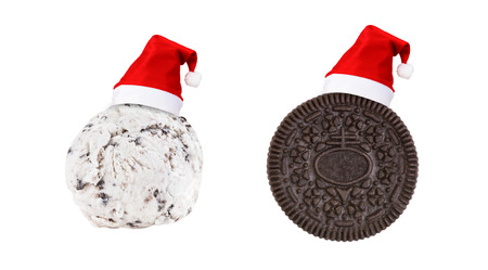 Santa Claus red hat on cookie and cream ice cream and cookie sandwich in piece isolated on white background (Clipping path included) to celebrate Christmas holiday season, new year party or special eventの写真素材