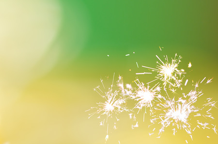 Sparkler light flame on green yellow bokeh gradient background with copy space for text, logo, wordings decoration for special occasion celebrationの写真素材