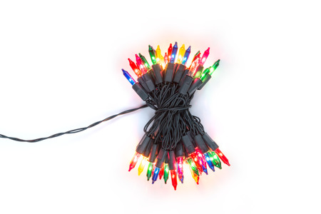 Christmas plugged light bulbs on string in bundle with multi colours; blue, yellow, red, pink and green isolated on white background, Xmas holiday decoration conceptの写真素材