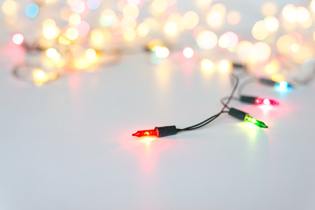 Christmas lights on string in multi colours; blue, yellow, green, pink & red on light grey...