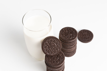 BANGKOK, Thailand - November 6, 2018: OREO cookies in stack with glass of fresh milk on white background (American famous cookie brand)の写真素材