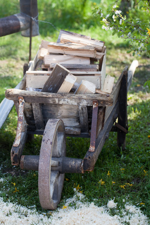 Firewood on a wooden wheel barrowの写真素材