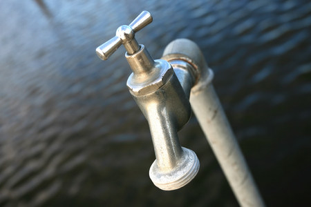 Faucet with water backgroundの写真素材