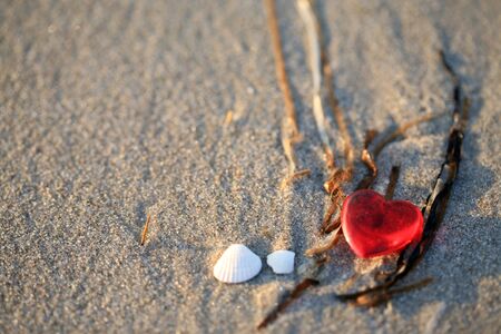 Red plastic heart on the beachの写真素材