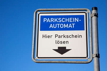 Sign with German text: Parking ticket machine. Get your parking ticket here. This translates into:...