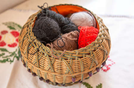 Wicker basket on a table with wool balls
