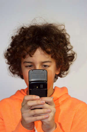 A boy is playing with his mobile phone            