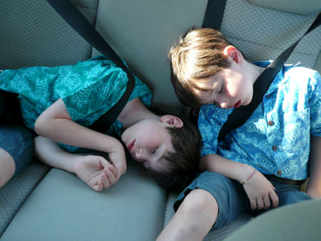 Tired young boys are sleeping in the carのeditorial素材