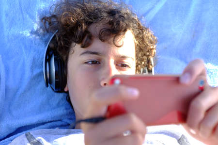 Young boy playing with his gadgetの写真素材