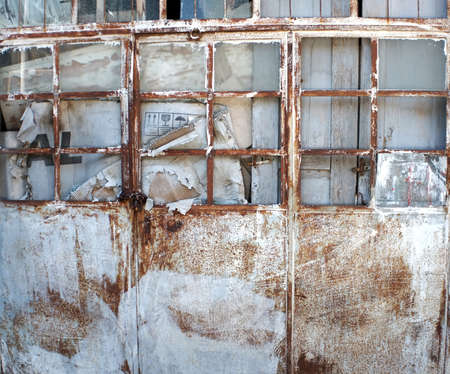 Abandoned rusty metal door of a buildingの写真素材