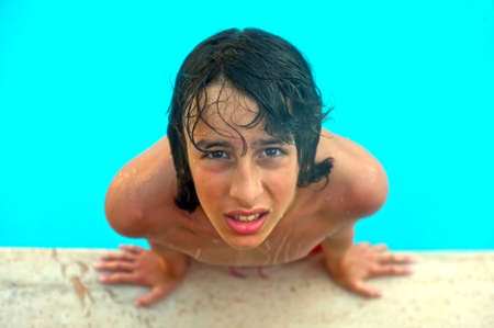 Young teenage boy looks up in swimming poolの写真素材