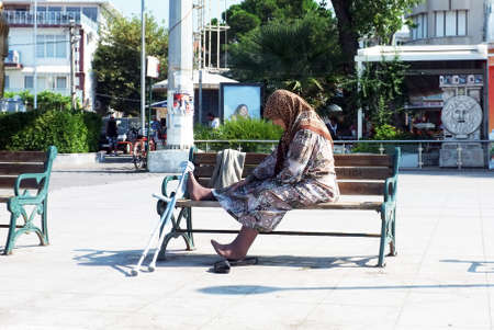 Elderly woman sits alone on benchのeditorial素材