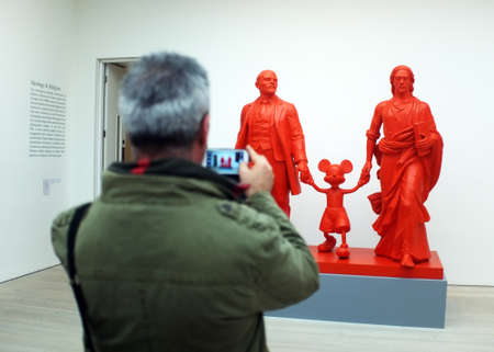 Visitor takes photo of the art work in a gallery