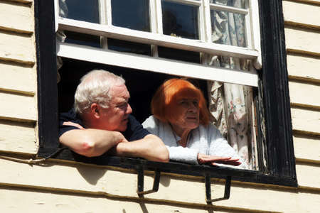 Elderly couple look out from their windowのeditorial素材
