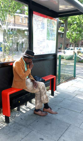 Elderly black man sitting at the bus stopのeditorial素材