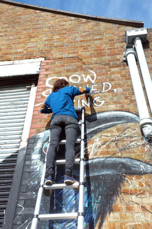 Graffiti artist paints the building wallのeditorial素材