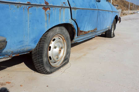 Flat tire of abandoned carの写真素材