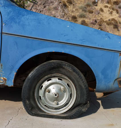 Flat tire of abandoned carの写真素材