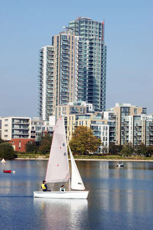 People sail on the reservoir surrounded by the buildingsのeditorial素材