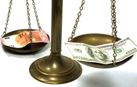 Dollar and Euro notes on scale in a conceptual photoの写真素材