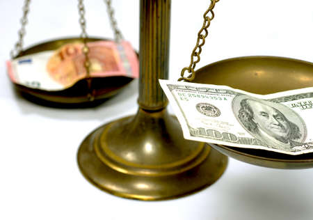 Dollar and Euro notes on scale in a conceptual photoの写真素材
