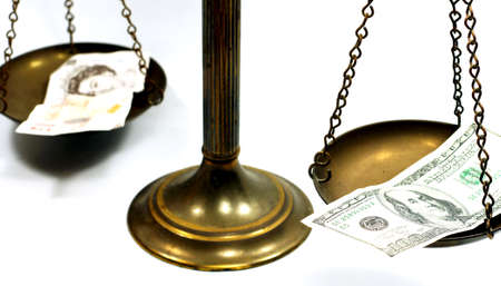 Pound and dollar notes on scale in a conceptual photoの写真素材