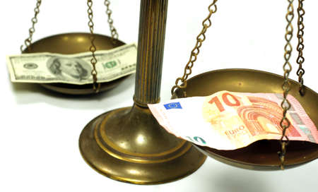 Dollar and Euro notes on scale in a conceptual photoの写真素材