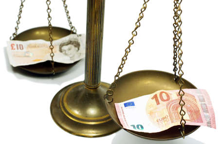 Pound and Euro notes on scale in a conceptual photoの写真素材