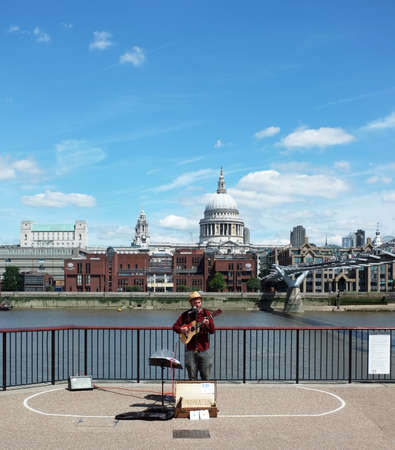 Street musician performs on Millennium Bridge near Tate Modern in Londonのeditorial素材