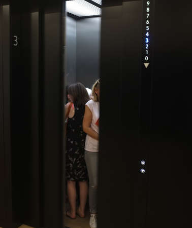 People in elevator waiting while doors are closing in New Tate building, London.のeditorial素材