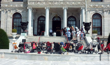Tourists leaves buggies in front of building while they are on queue for tickets to visit Dolmabahce Palace in Istanbul, Turkey.のeditorial素材