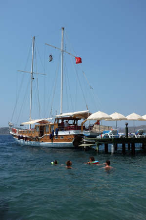 Family swim near jetty and docked boat during summer holiday in Marmaris, Turkeyのeditorial素材