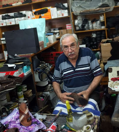Elderly shoemaker works in his workshop in Edremit. Istanbulのeditorial素材