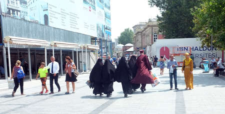 Group of veiled muslim women walk with a man in Istanbul's Eminonu district.のeditorial素材