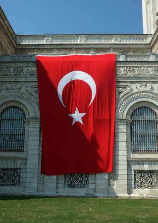 Giant Turkish flag hanging on the wall of Dolmabahce Palace in Istanbulの写真素材