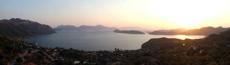 Panoramic dusk view from above with sea and mountainsの写真素材