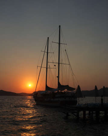 Yacht and jetty silhouettes at dawn in Marmaris, Turkeyの写真素材
