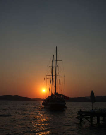 Yacht and jetty silhouettes at dawn in Marmaris, Turkeyの写真素材